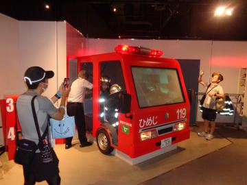 参加者が模擬消防車へ乗り込んでいる様子