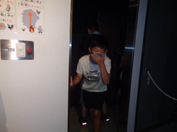 参加者が煙からの避難行動を体験する様子