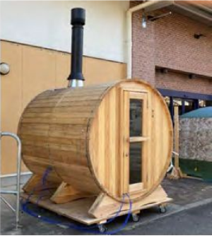 横向きに設置された木製のバレル内にサウナが設置されている