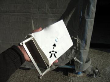 大きい鏡を穴をあけた紙で覆ったもの