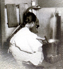 蛇口から水を汲む女性の写真