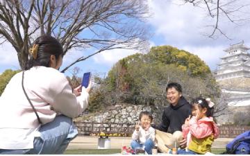 姫路城の前で家族が写真撮影している様子