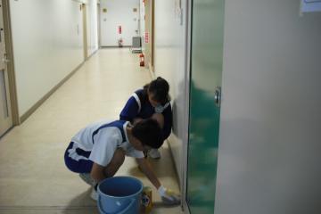 生徒による廊下の床磨き作業の様子