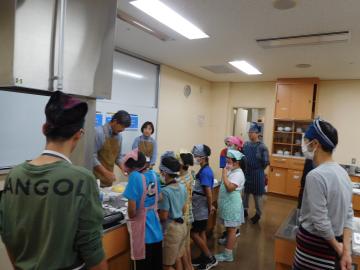 参加者が調理室で講師の説明を聞いている様子