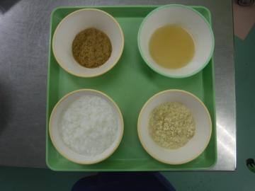 トレーの上で食器に盛られたかゆ・きざみ食の画像