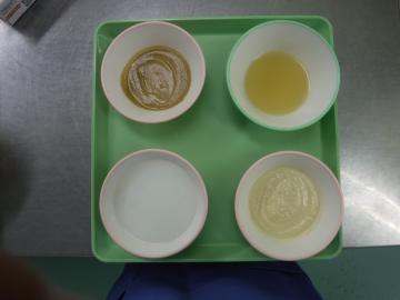 トレーの上で食器に盛られた流動がゆ・流動食の画像