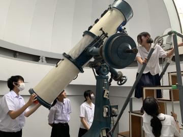 生徒が反射望遠鏡を使用している様子の写真