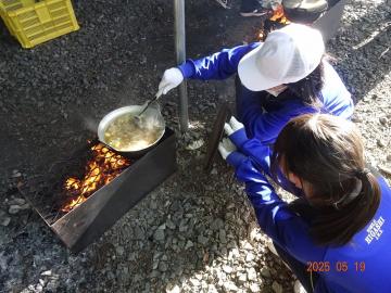 屋外でカレー調理をしている生徒の様子