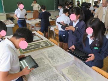 資料を撮影する6年生