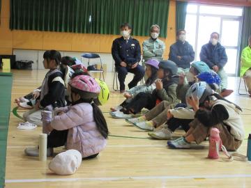 体育館内でヘルメットの大きさが体に合っているかを確かめている児童たちの様子