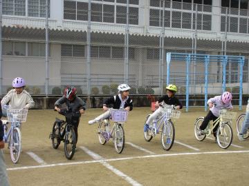 校庭で自転車にまたがる児童たちの様子