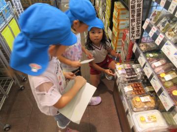 販売店内で団子の値段を調べる5歳児たちの様子