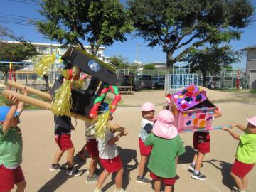 園庭でお祭りごっこをする園児たちの様子