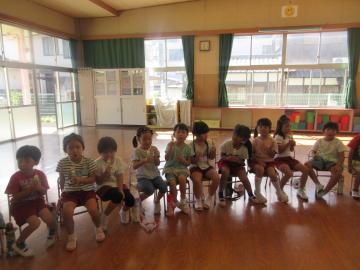 遊戯室内においてお月見会で団子を食べる園児たちの様子