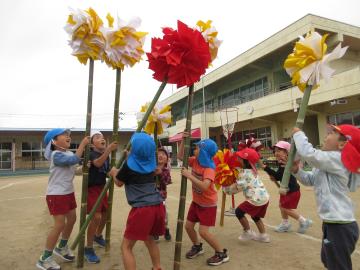 園庭でシデを振る園児たちの様子