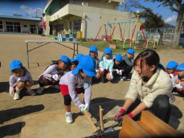 園庭で薪割りをする5歳児たちの様子