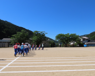 晴天の中、全校練習をする子供達の様子