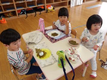 美味しそうに柏餅を食べる幼児
