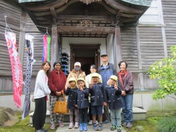 山本家の玄関の前で記念撮影する参加者たちの様子