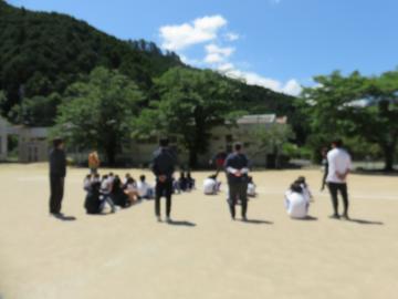 運動場に避難をして校長先生の話を聞く児童達