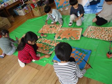 室内でじゃがいもの絵を描く園児の様子