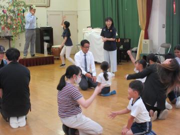 屋内で、園児たちが親子でジャンケン遊びをしている様子
