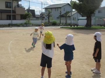 園児たちが園庭でリレーする様子