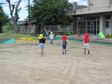 園児たちが園庭でトンボとりをしている様子