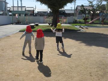 園庭でだるまさんが転んだの合図で止まっている園児たちの様子