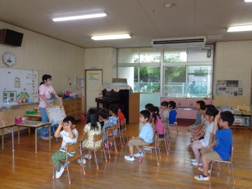 幼児が朝の会で話を聞いているところ