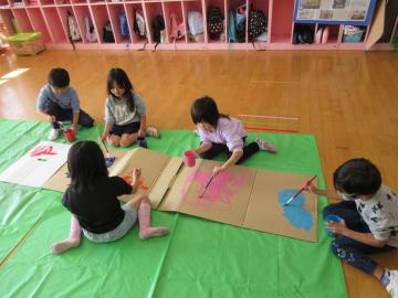 ダンボールに絵具を塗っている
