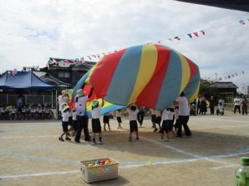 園庭で4歳児がパラバルーンをしている様子