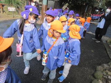 園内で3歳児が5歳児と手をつないで歩いている様子