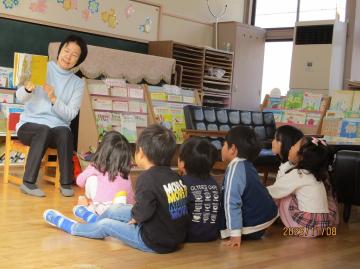 遊戯室で4歳児がお話を聞く様子