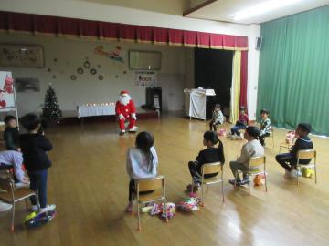 遊戯室内でサンタさんに質問している園児たちの様子