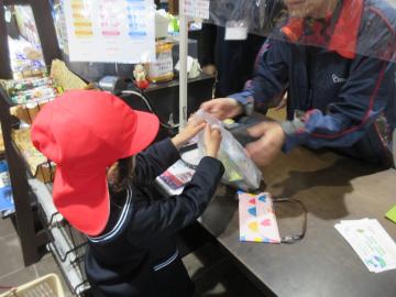 館内のレジでお金を払い商品をもらう園児たちの様子