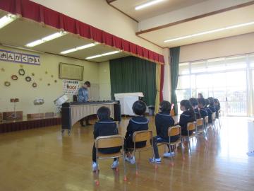 遊戯室内でマリンバ演奏を聴いている園児たちの様子