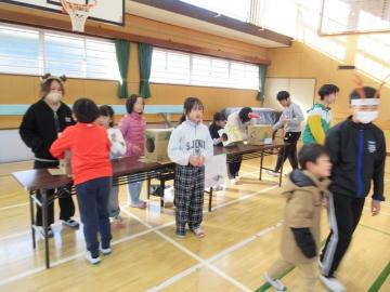 子供が箱の中身を手で触って当てようとしています
