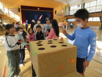 子供が、穴から出てくるペットボトルをたたいています。