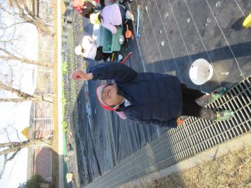 屋外で、氷を覗き空を見ている園児の様子