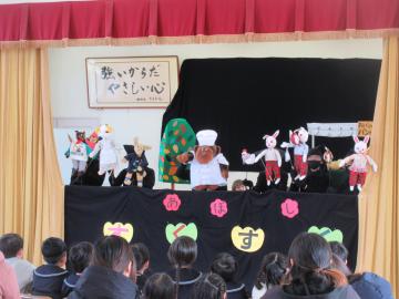 遊戯室壇上で演じられている人形劇を鑑賞する園児たちの様子