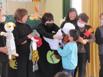 遊戯室で人形に触れている園児たちの様子