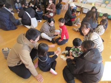 室内で親子でトランプをしている園児たちの様子