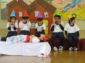 劇の中で、白雪姫が魔女の毒リンゴを食べて、目を覚まさないので、小人たちが悲しんでいる姿を演じる園児たちの様子