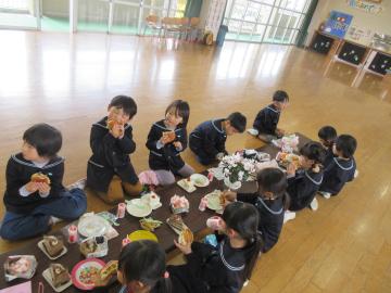 長机を並べ、皆で正座して昼食を食べている様子