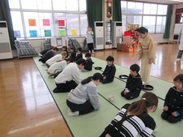 親子で向かい合いって座り、親がお辞儀をしているところ