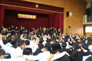 生徒が肩を組んで歌う様子