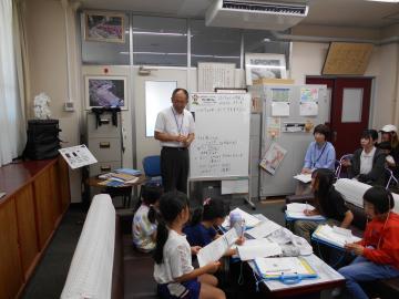 まちたんけんで児童が校長に質問する様子