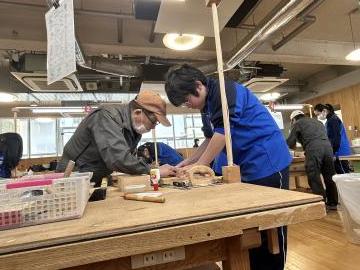 室内で生徒がマルチボックスづくりで熟練技能者から指導を受ける様子
