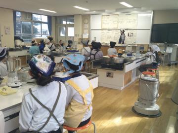 児童が教師の説明を座って聞く様子